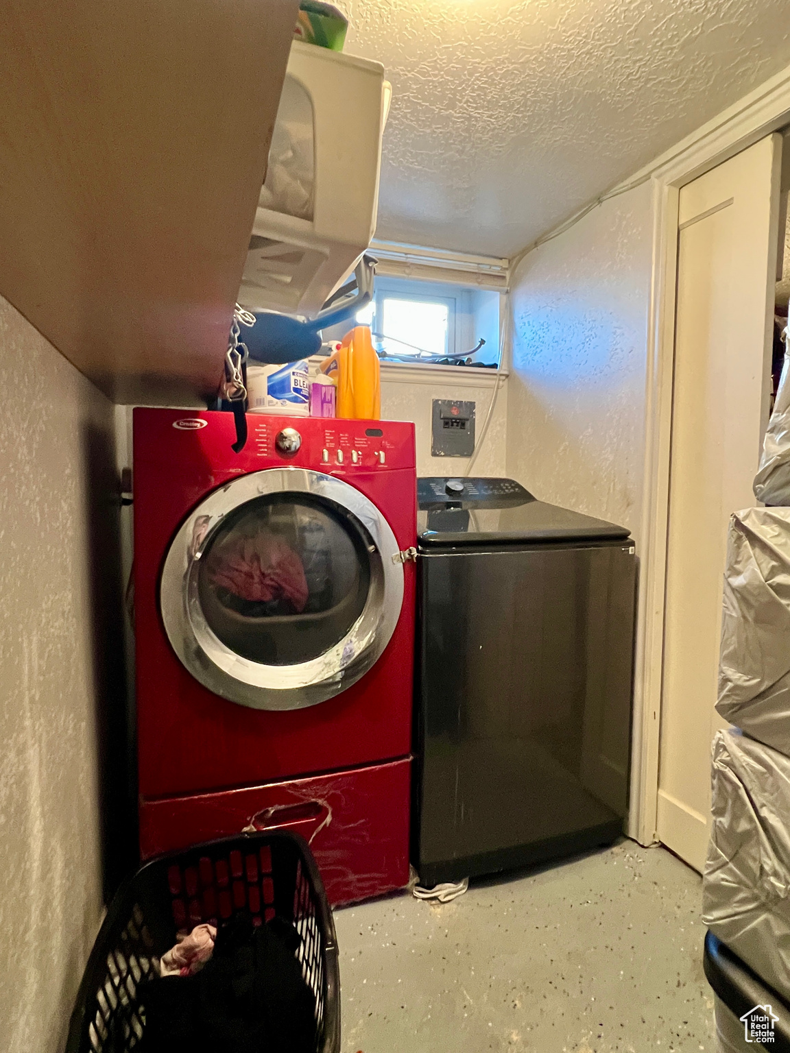 Washroom featuring a textured ceiling and separate washer and dryer