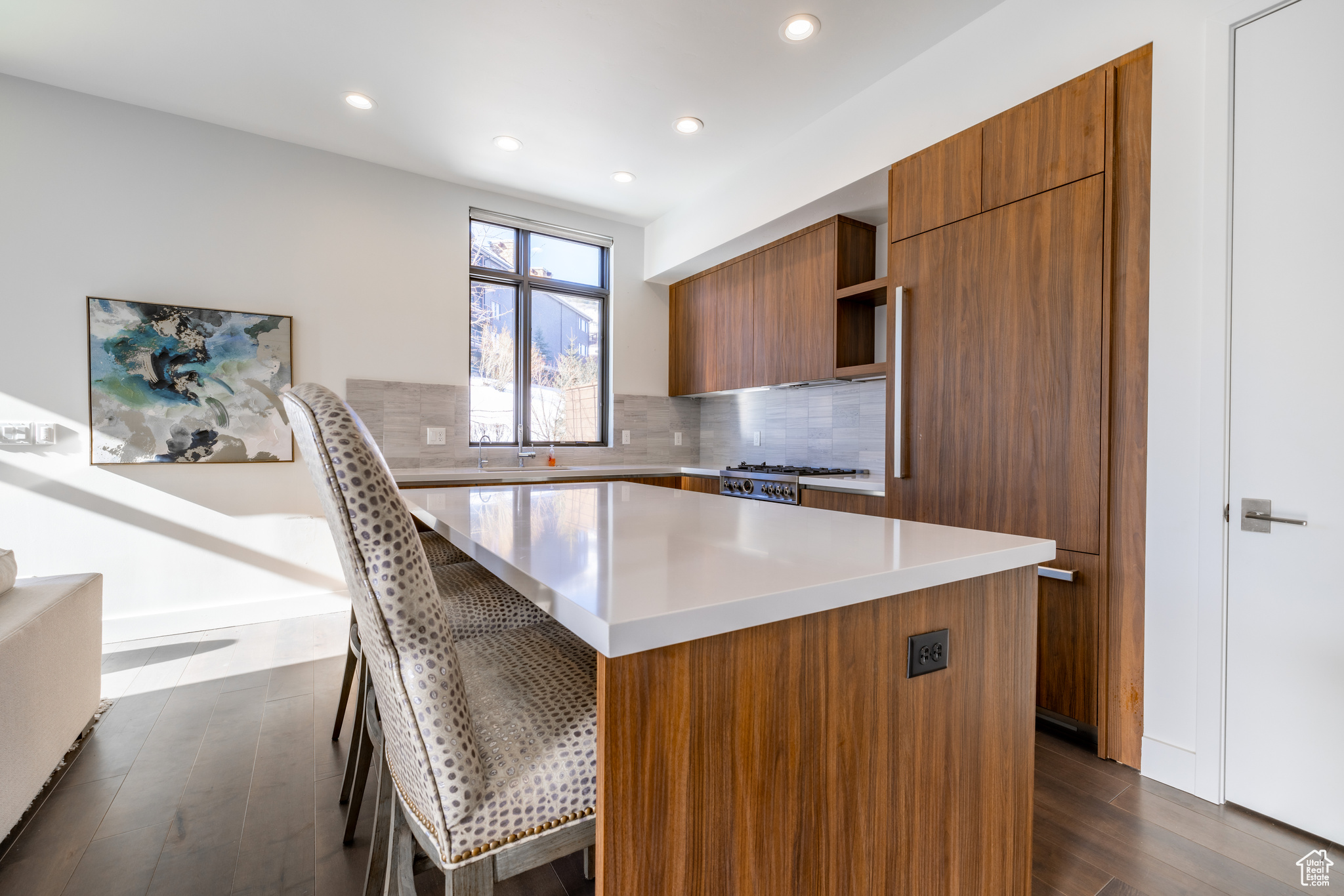 Kitchen with a kitchen breakfast bar, a center island, dark hardwood / wood-style floors, stove, and tasteful backsplash