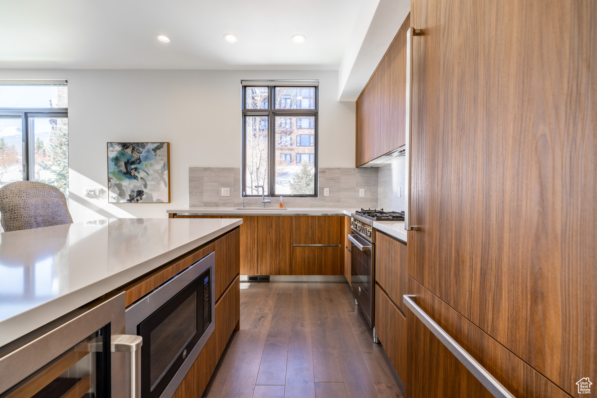 Kitchen featuring high end stove, built in microwave, tasteful backsplash, dark hardwood / wood-style flooring, and wine cooler