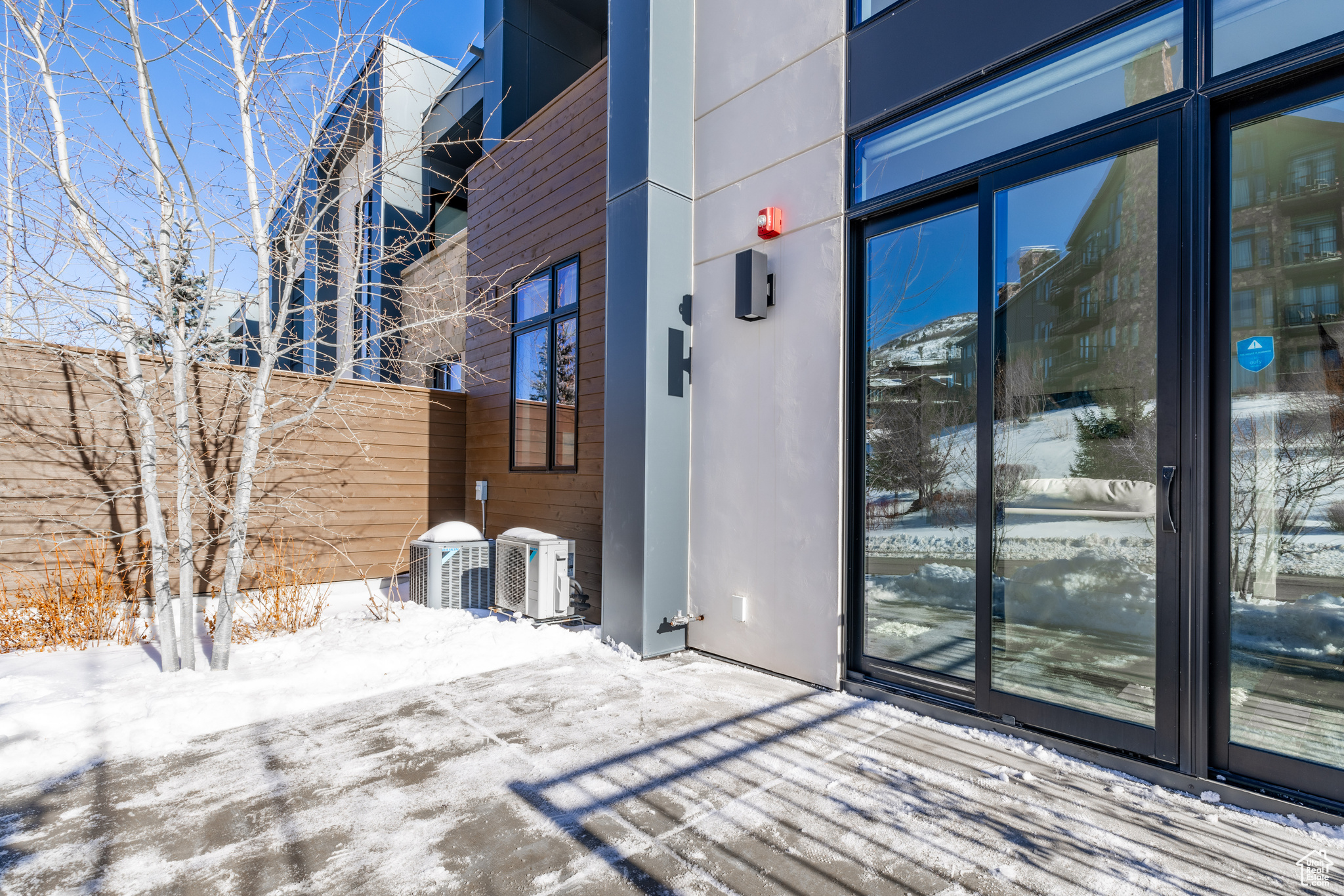 Snow covered property entrance with central air condition unit