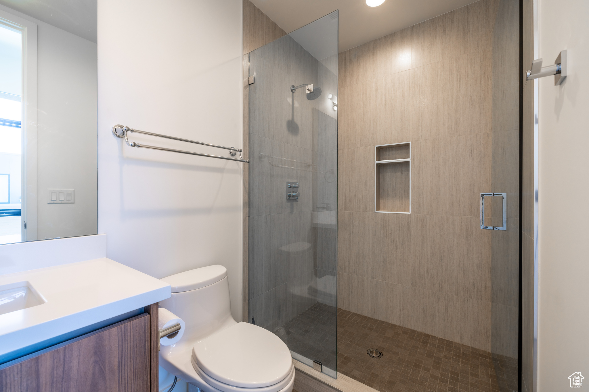 Bathroom with an enclosed shower, vanity, and toilet