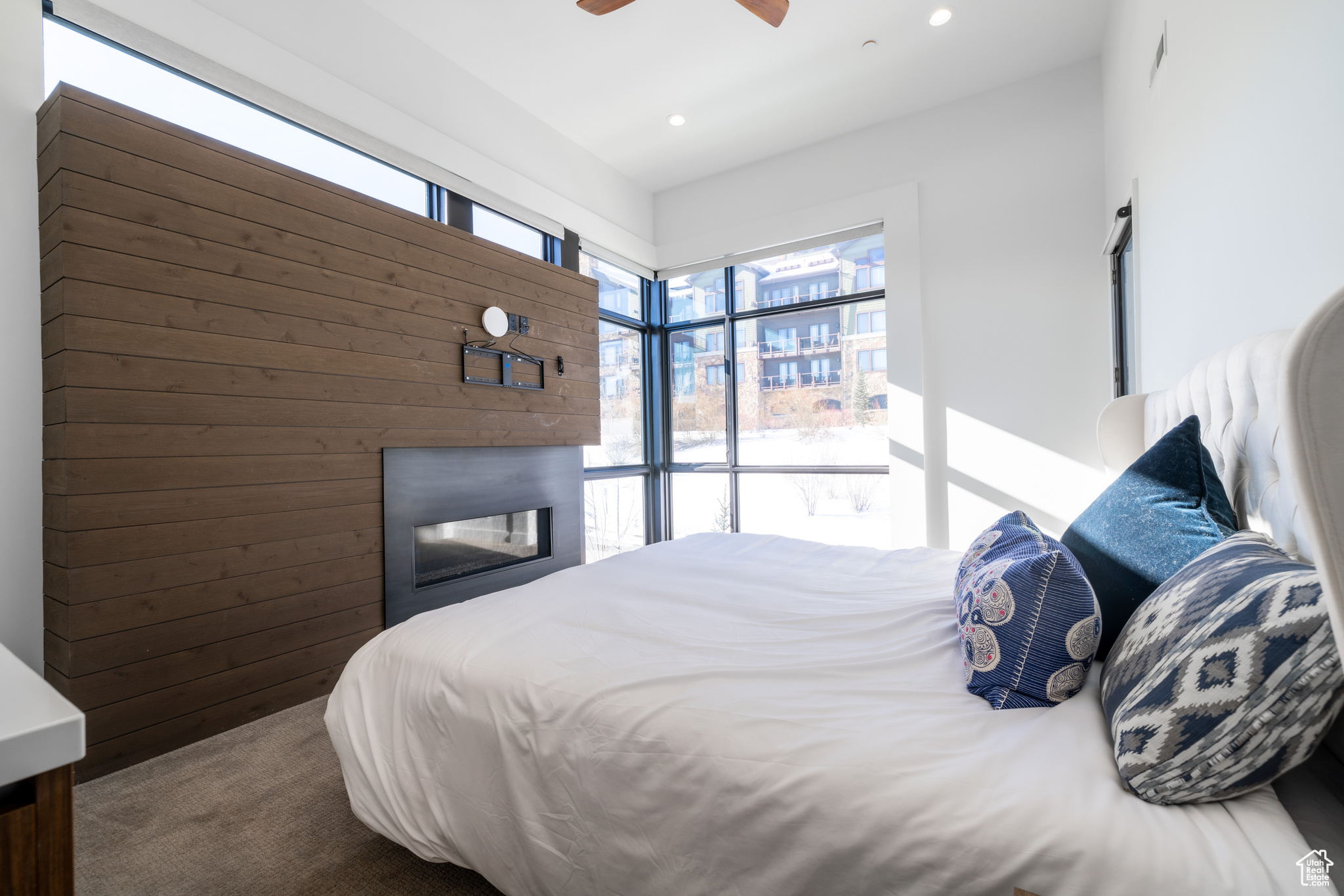 Bedroom with ceiling fan and wood walls