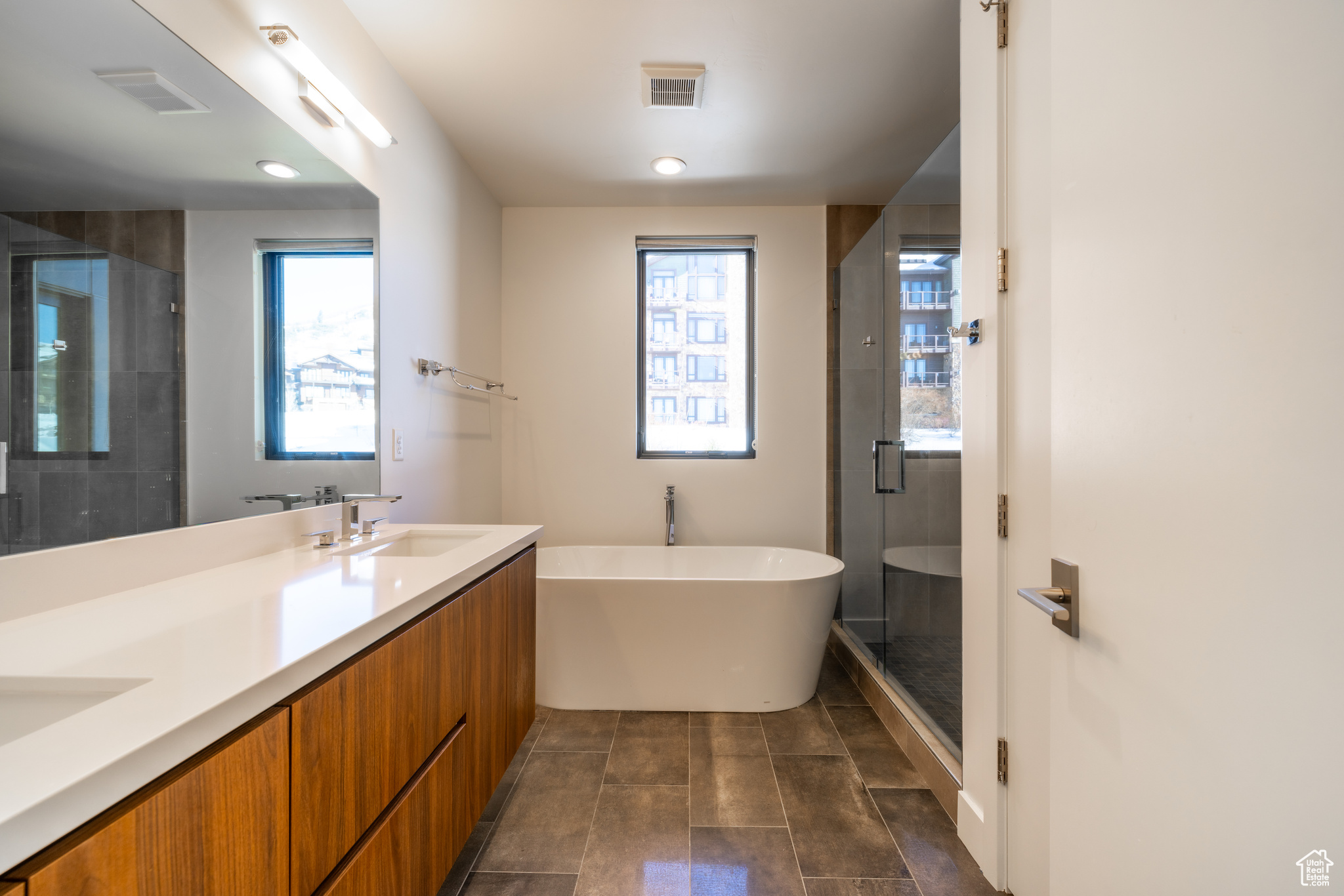 Bathroom featuring tile patterned flooring, vanity, and shower with separate bathtub