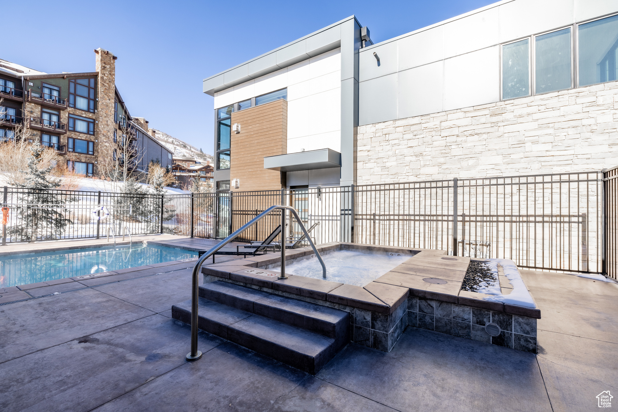 View of pool with a patio area and a hot tub