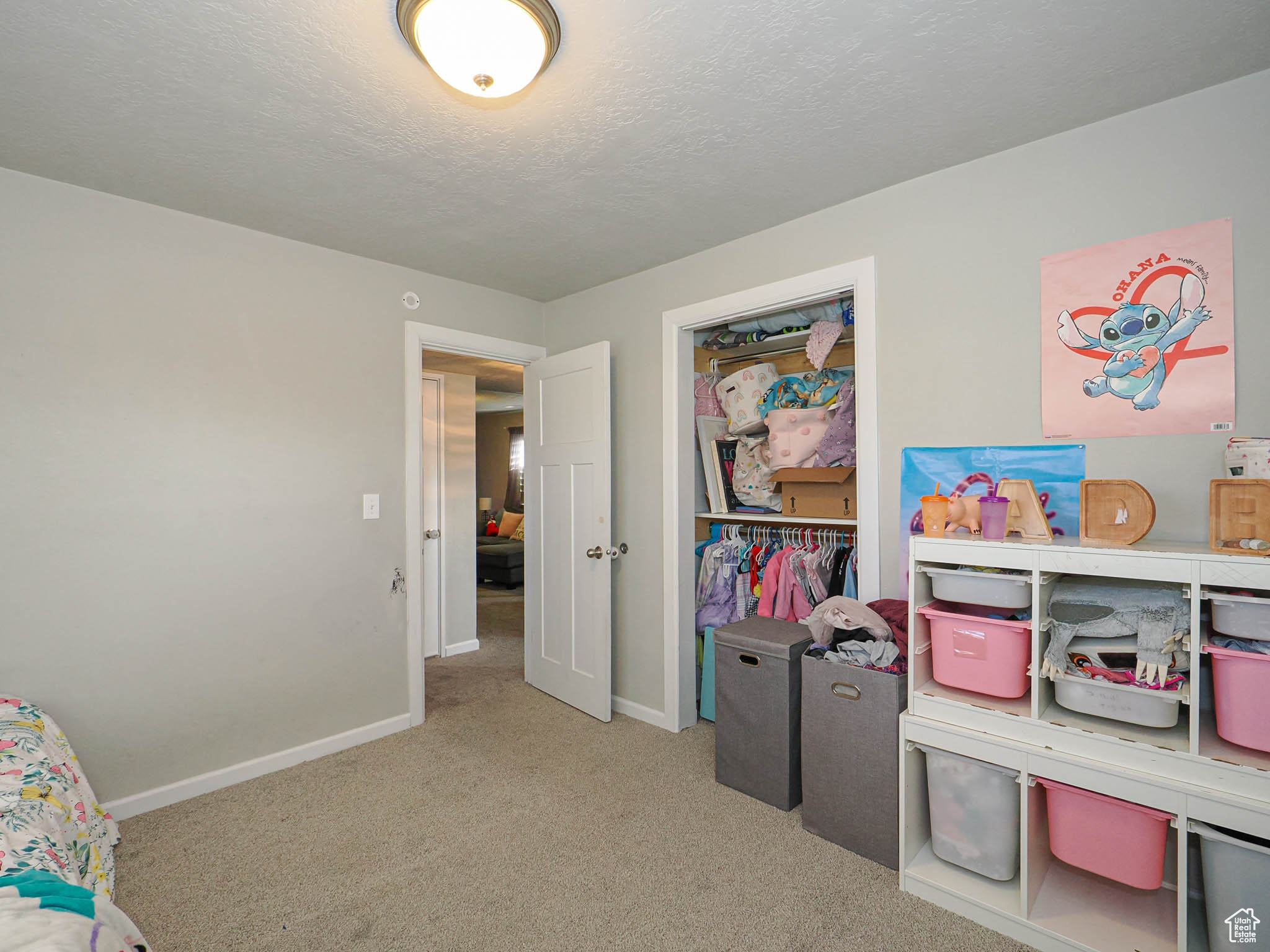 Playroom with a textured ceiling and light carpet