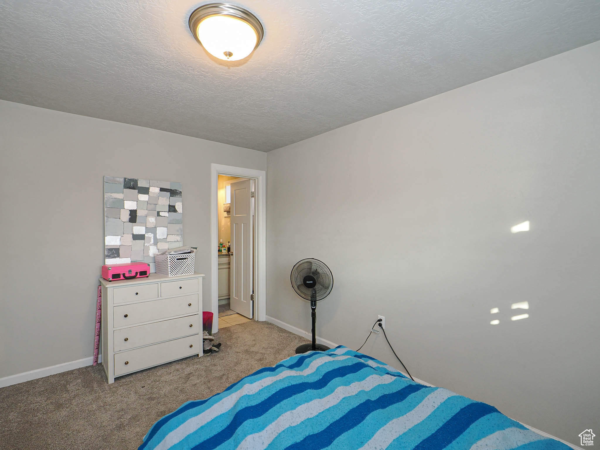 Carpeted bedroom featuring a textured ceiling