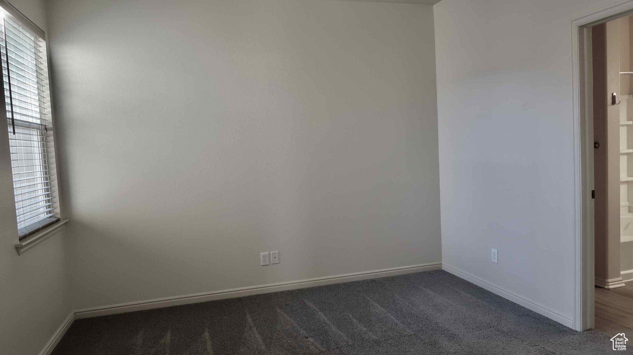 Unfurnished room with dark carpet