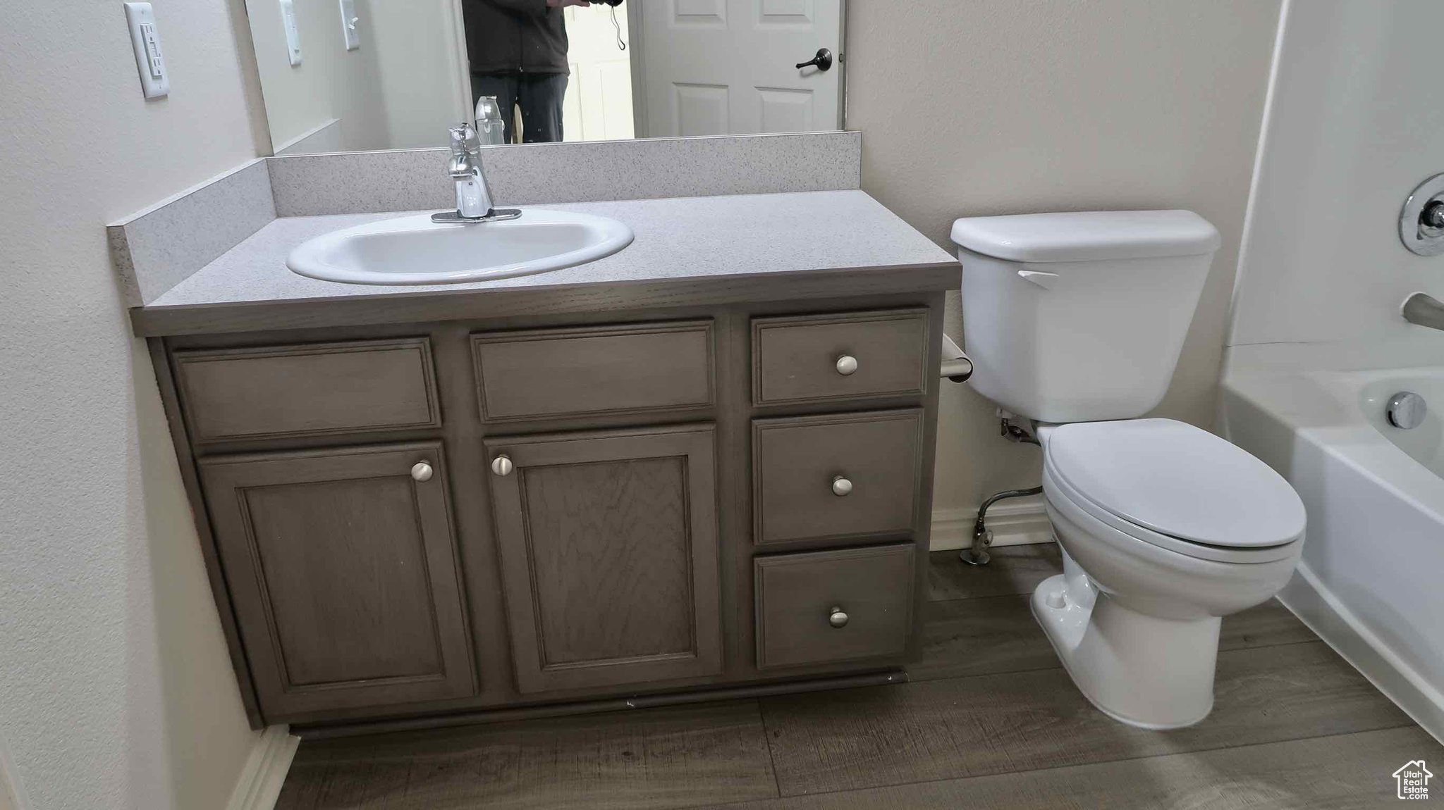 Full bathroom with hardwood / wood-style flooring, vanity, toilet, and bathing tub / shower combination