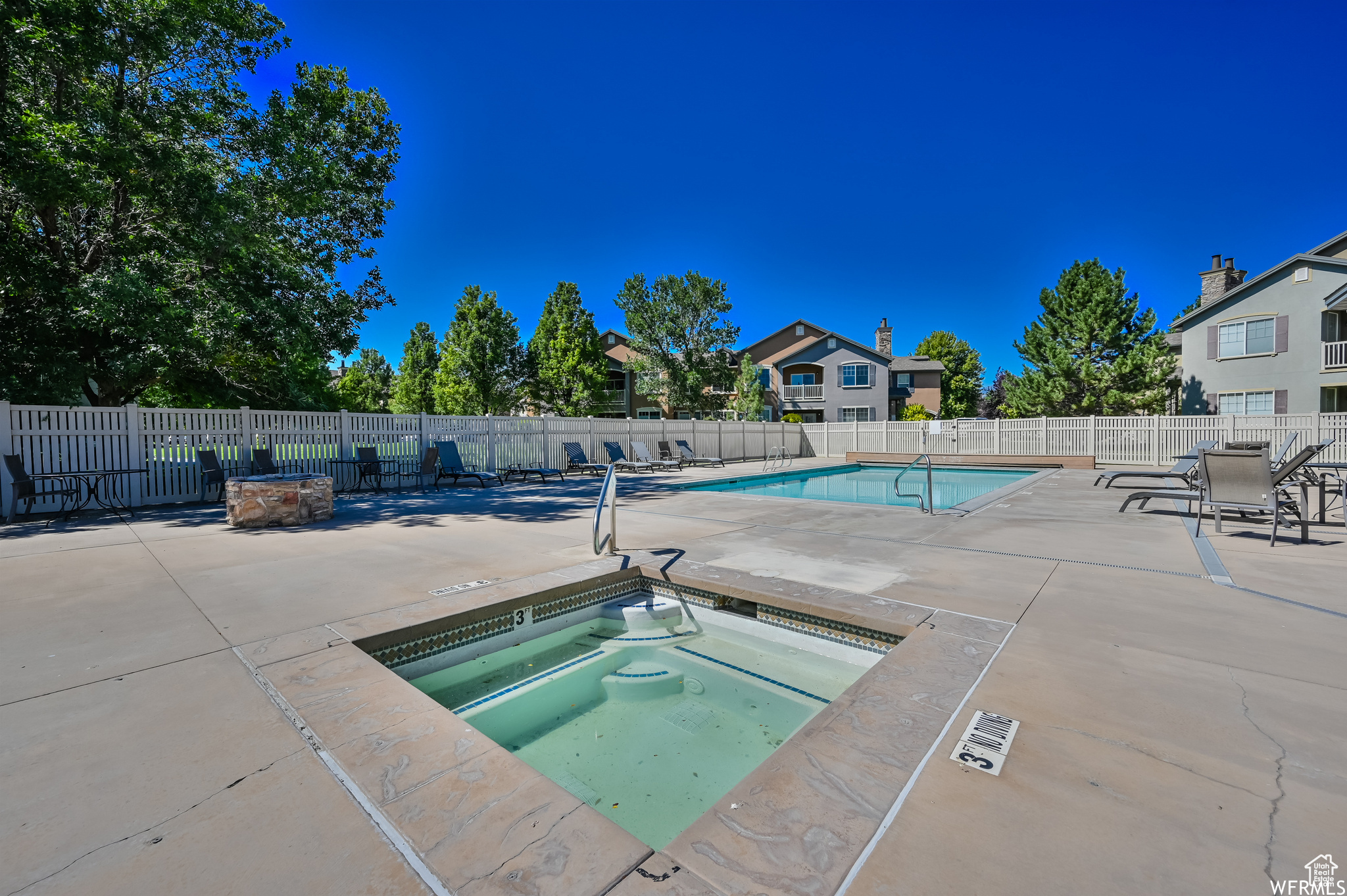 View of pool with a patio area and a hot tub