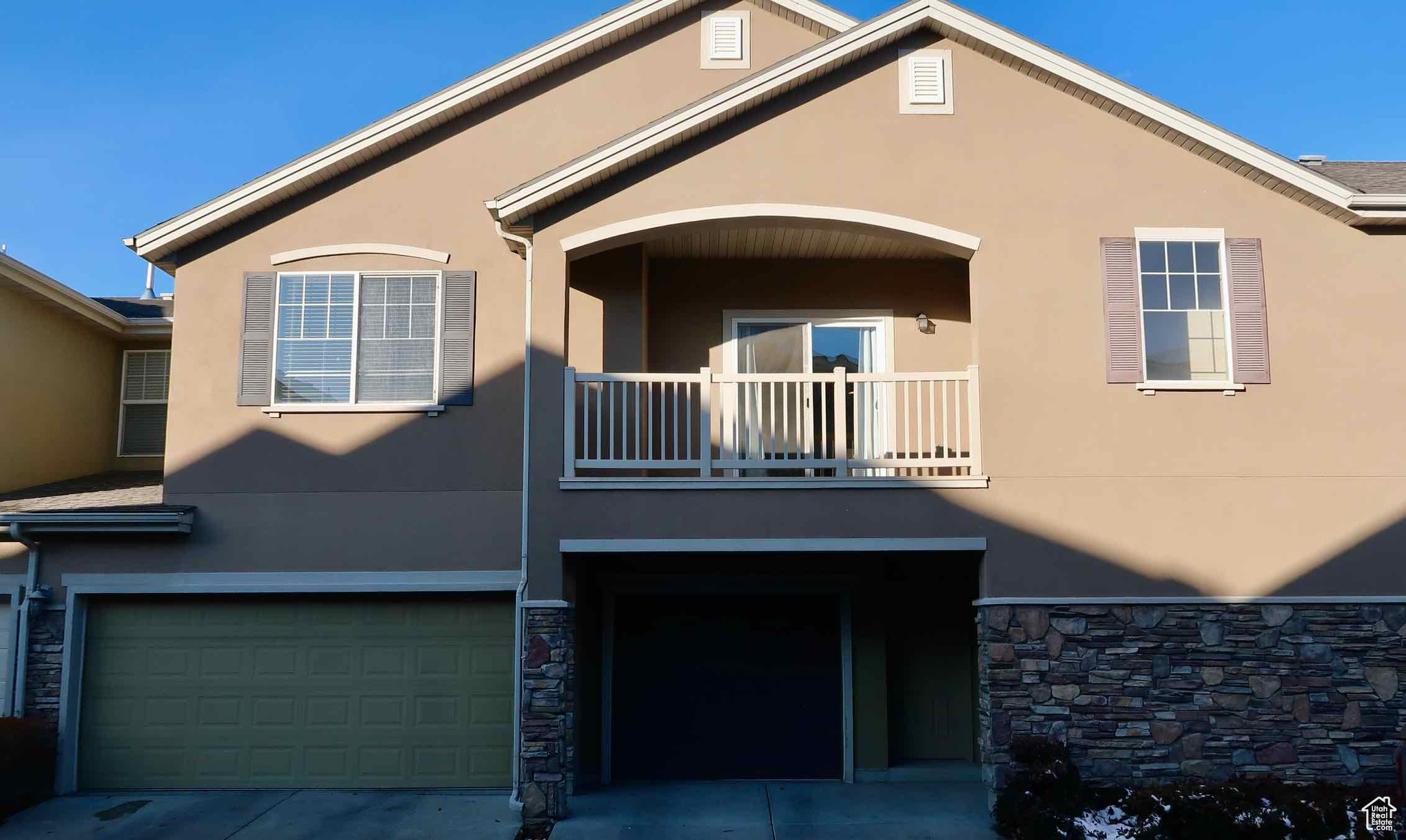 View of front of property with a balcony and a garage