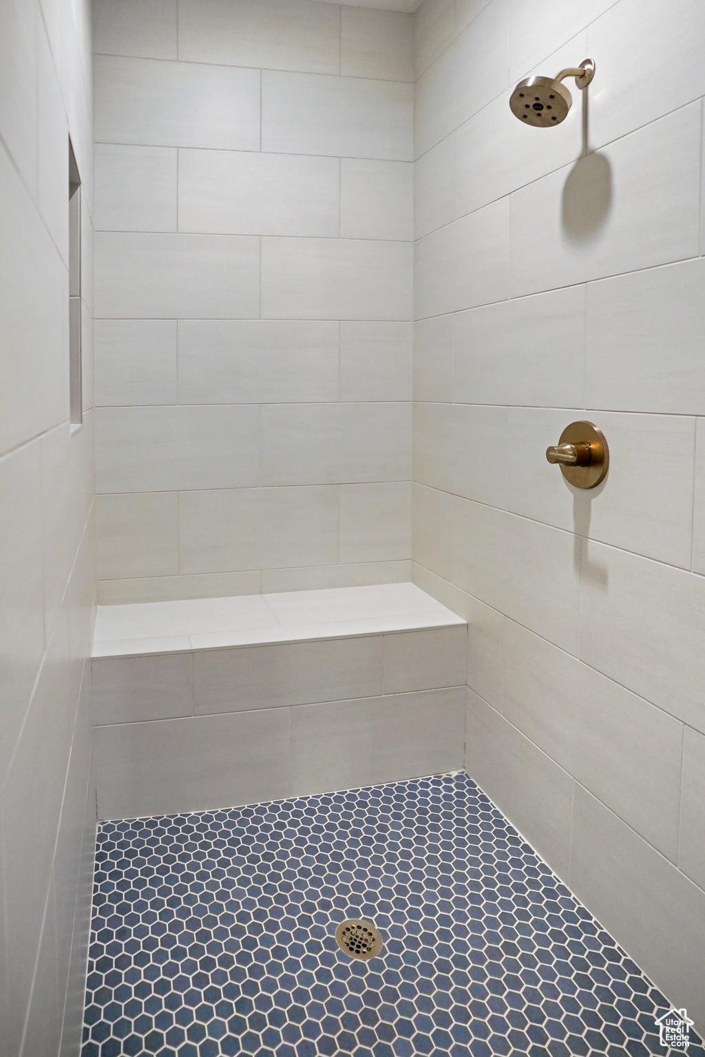 Extra deep shower (much wider than it appears) with brushed 'gold' Delta Trinsic fixture, in-set niche and shower bench area. A euro-style glass door provides added warmth and an elegant finished look.