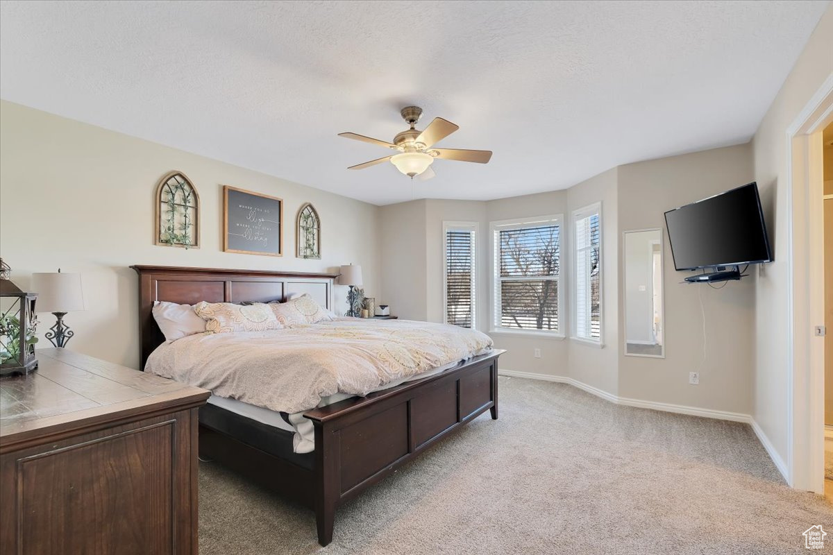 Bedroom with light carpet and ceiling fan