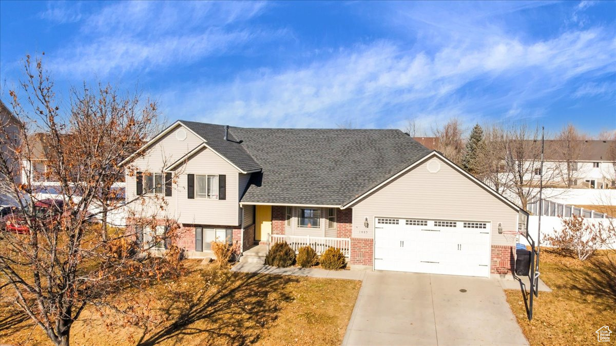 Split level home featuring covered porch and a garage