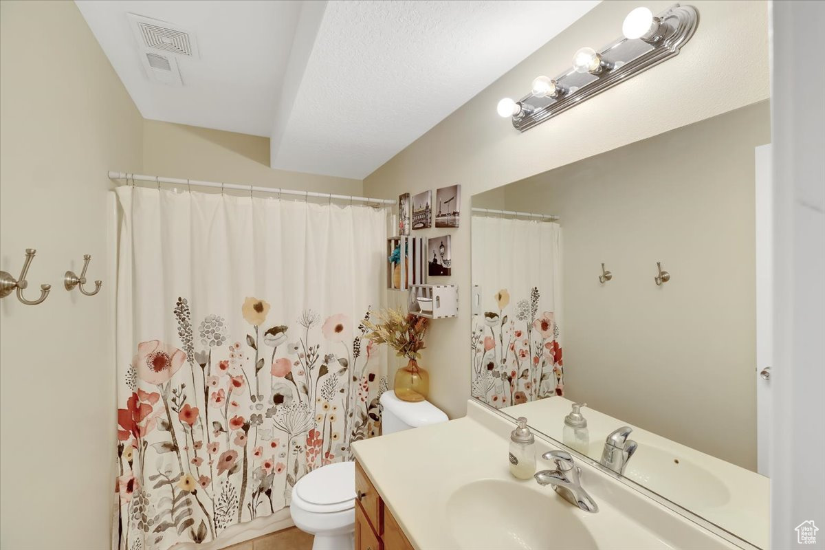 Bathroom with toilet, vanity, and walk in shower