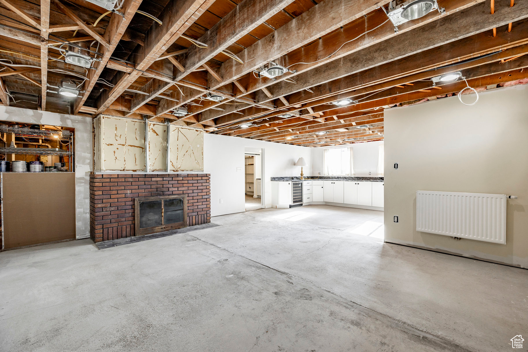 Basement featuring a brick fireplace, radiator heating unit, and wine cooler