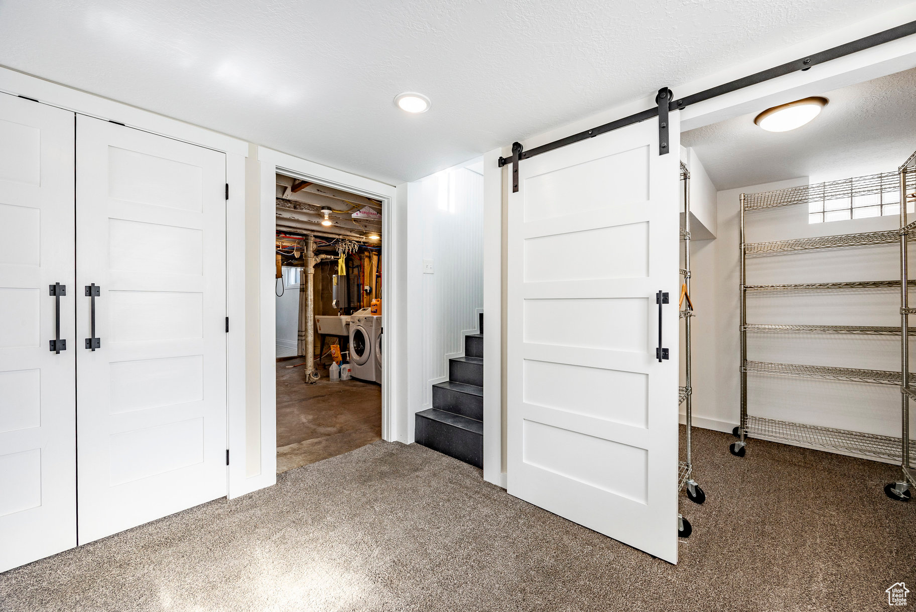 Basement featuring a barn door, independent washer and dryer, and a textured ceiling