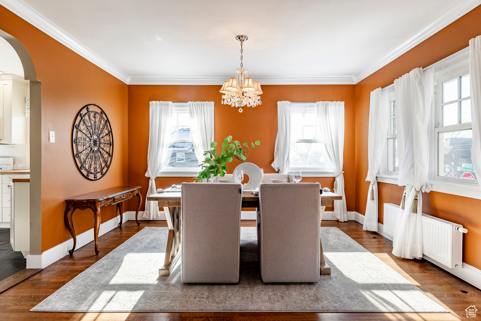 Dining space featuring a healthy amount of sunlight, wood-type flooring, and a chandelier