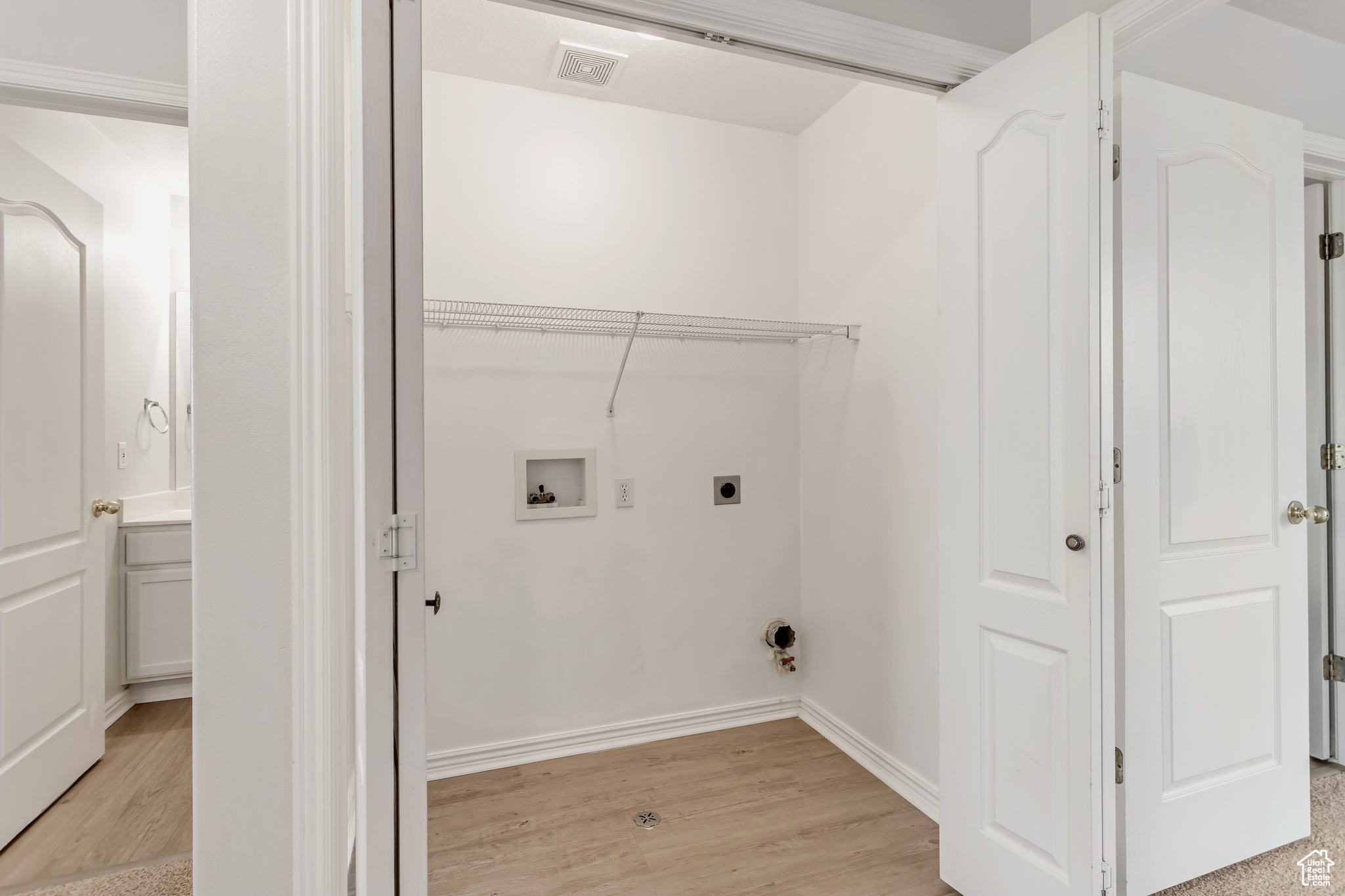 Washroom featuring light hardwood / wood-style floors, electric dryer hookup, and hookup for a washing machine