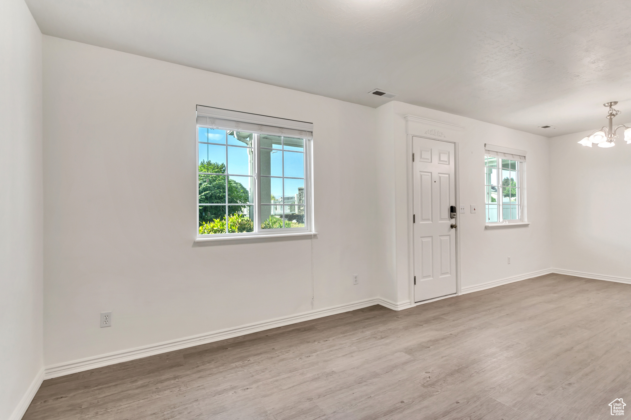 Foyer entrance featuring a chandelier and wood-type flooring