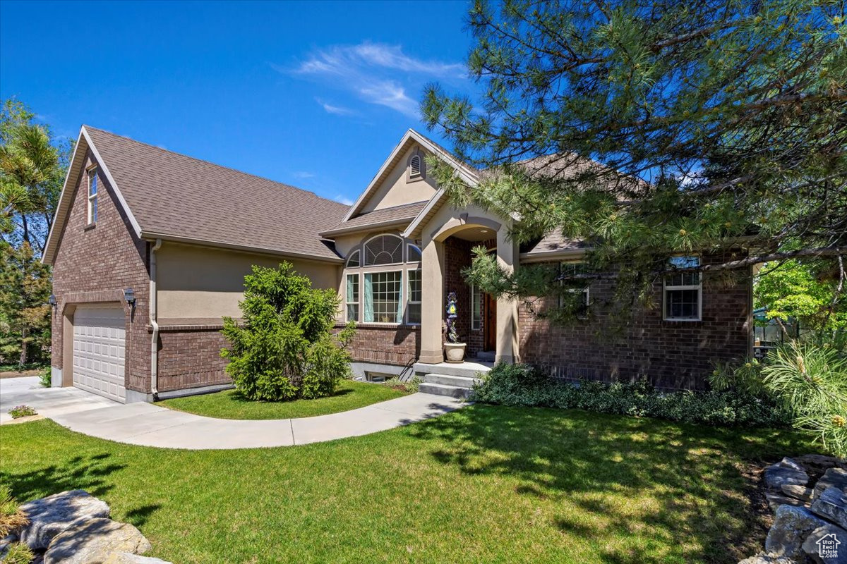 View of front facade featuring a front lawn and a garage