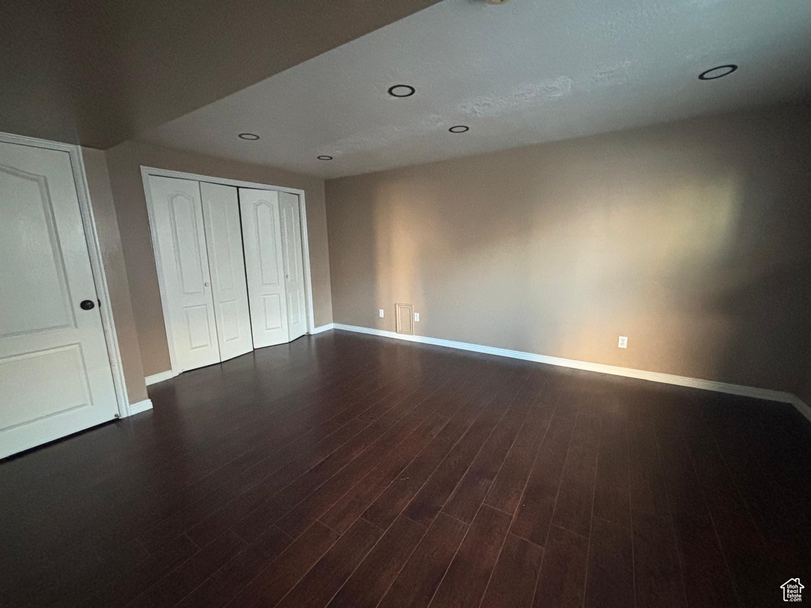 Bedroom with a closet and dark hardwood / wood-style floors