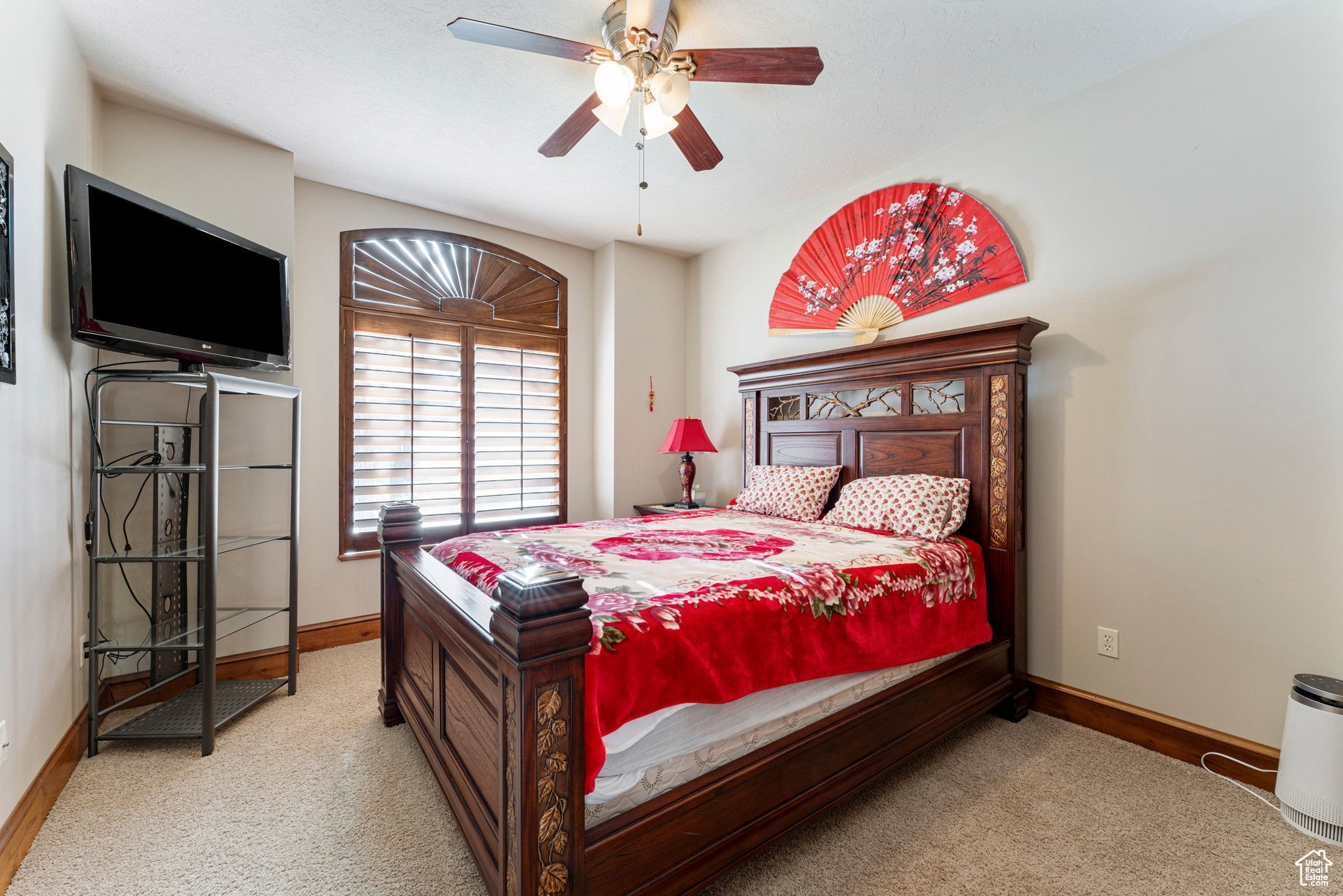 Carpeted bedroom featuring ceiling fan