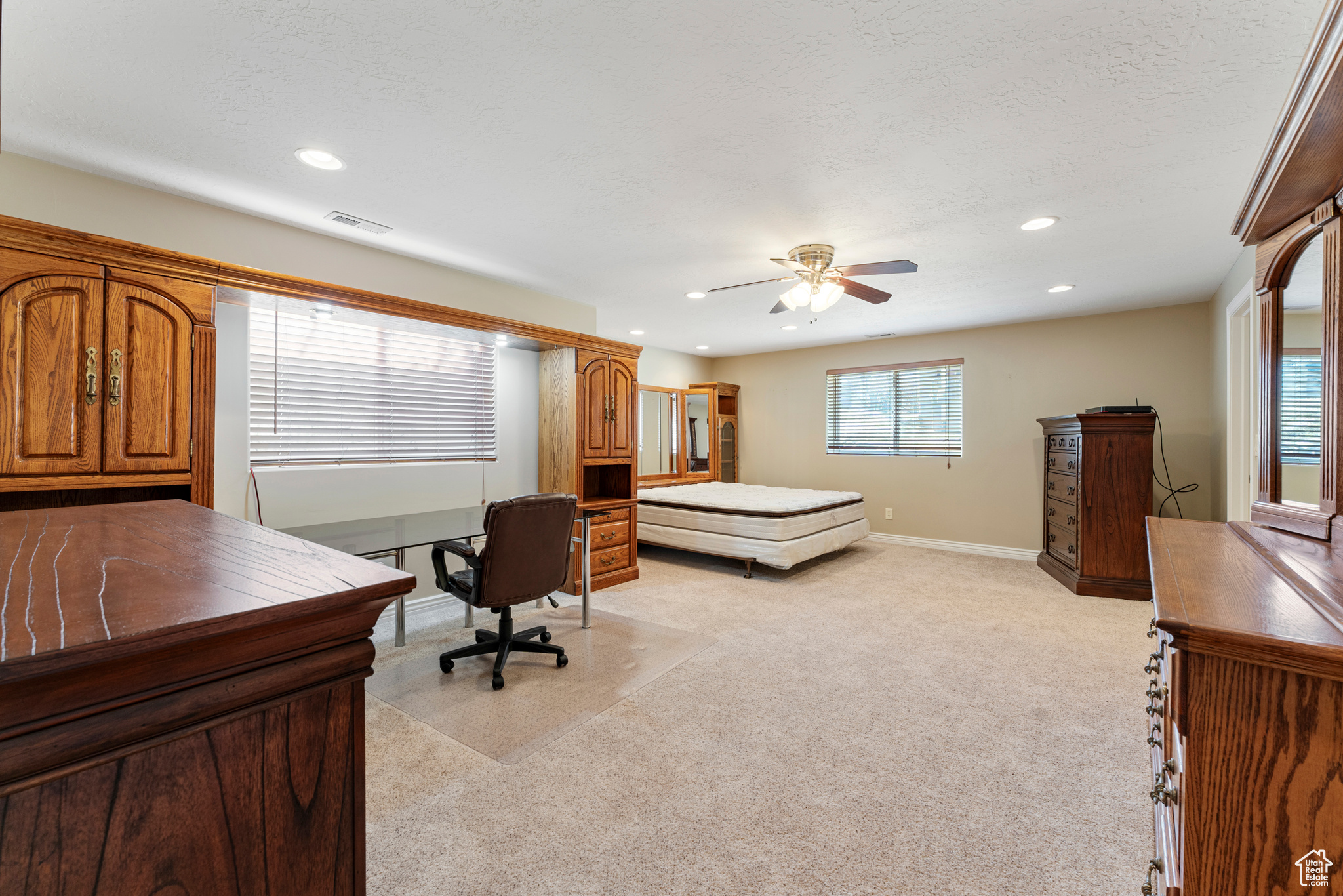 Carpeted bedroom featuring a textured ceiling and ceiling fan