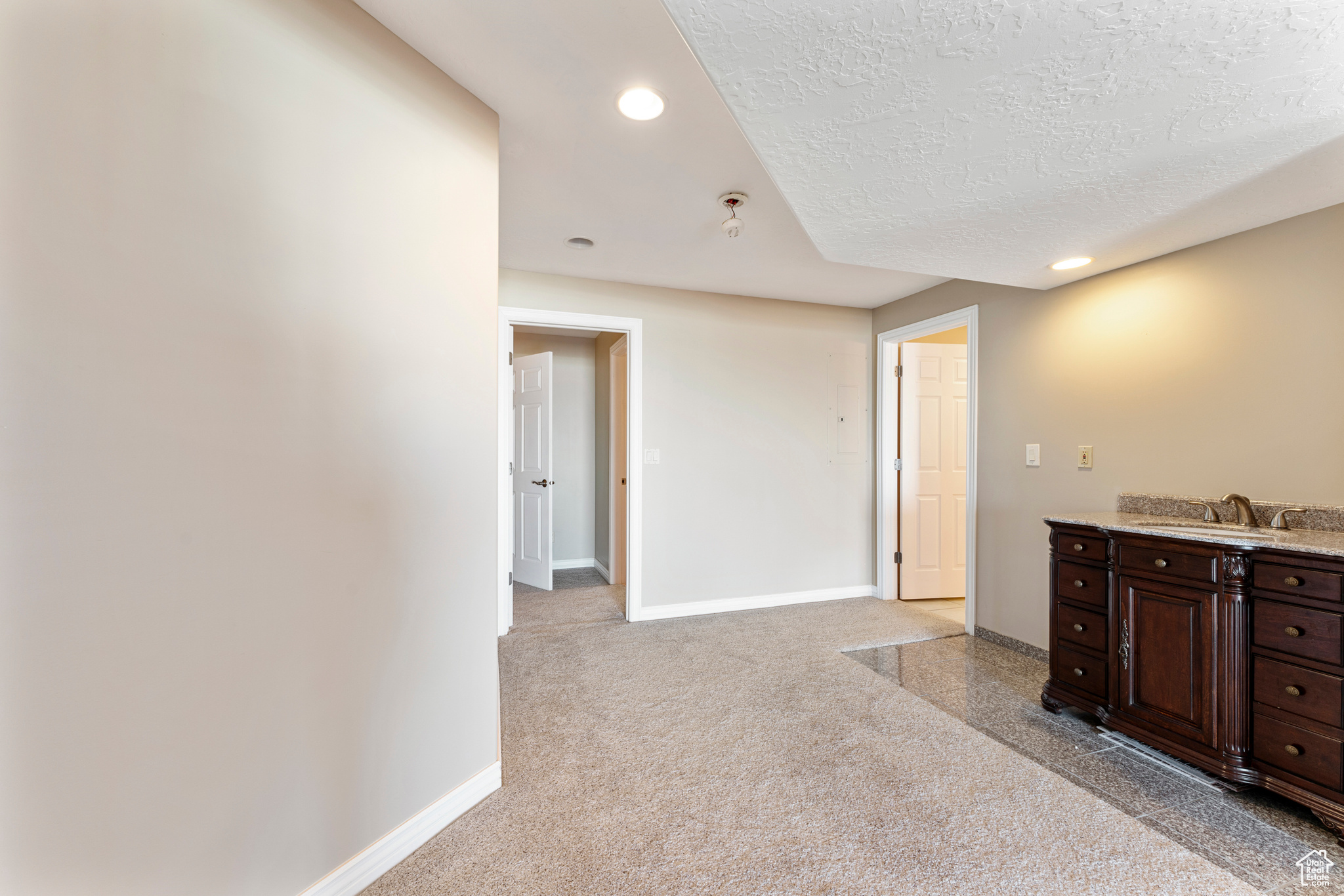 Interior space featuring sink, dark brown cabinets, and a textured ceiling