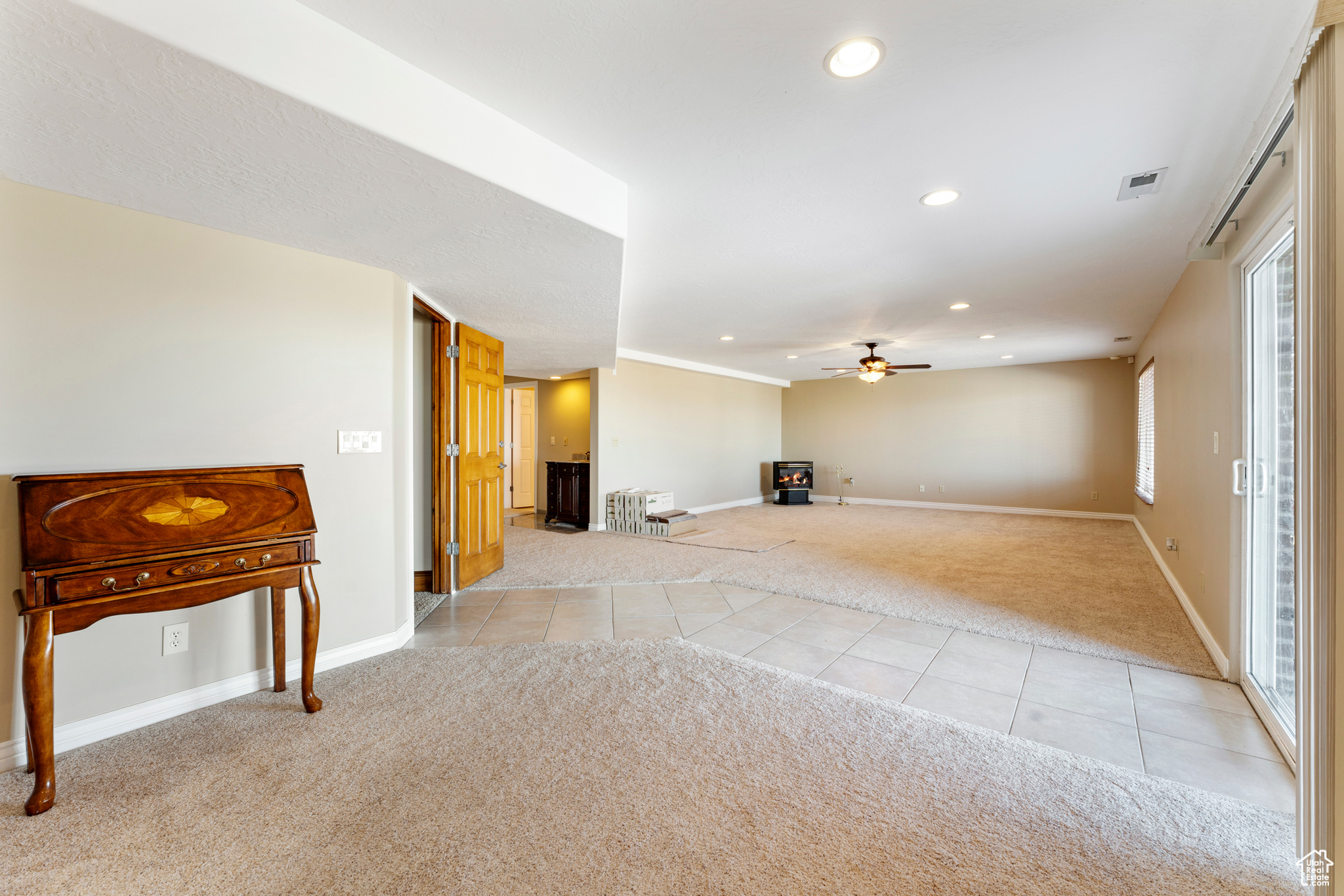 Interior space with plenty of natural light, light carpet, and ceiling fan