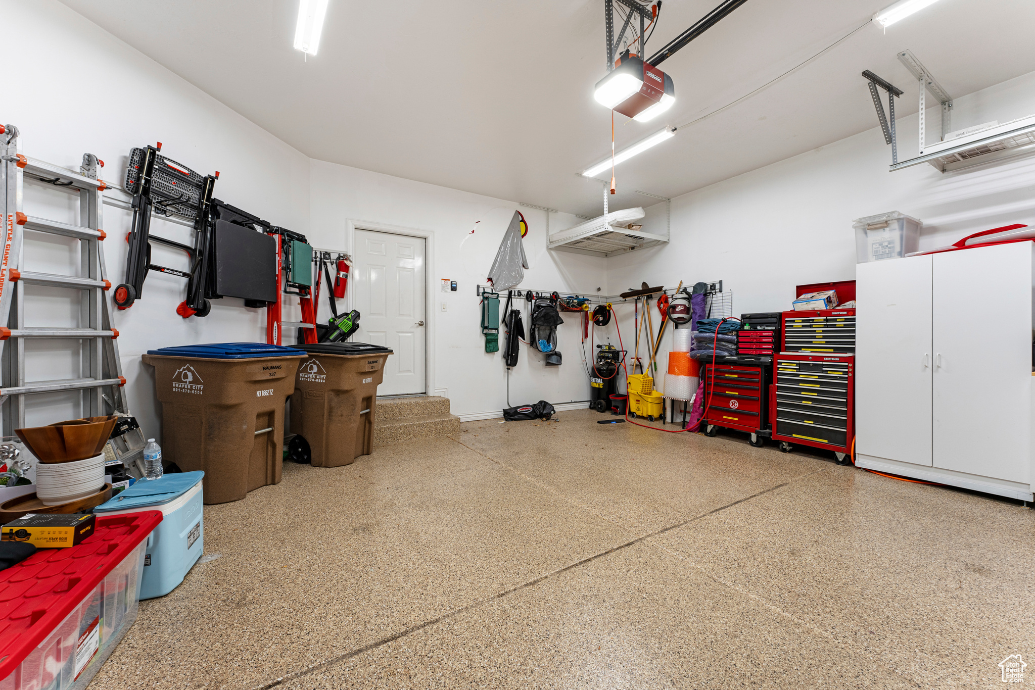 Garage featuring a garage door opener and a workshop area