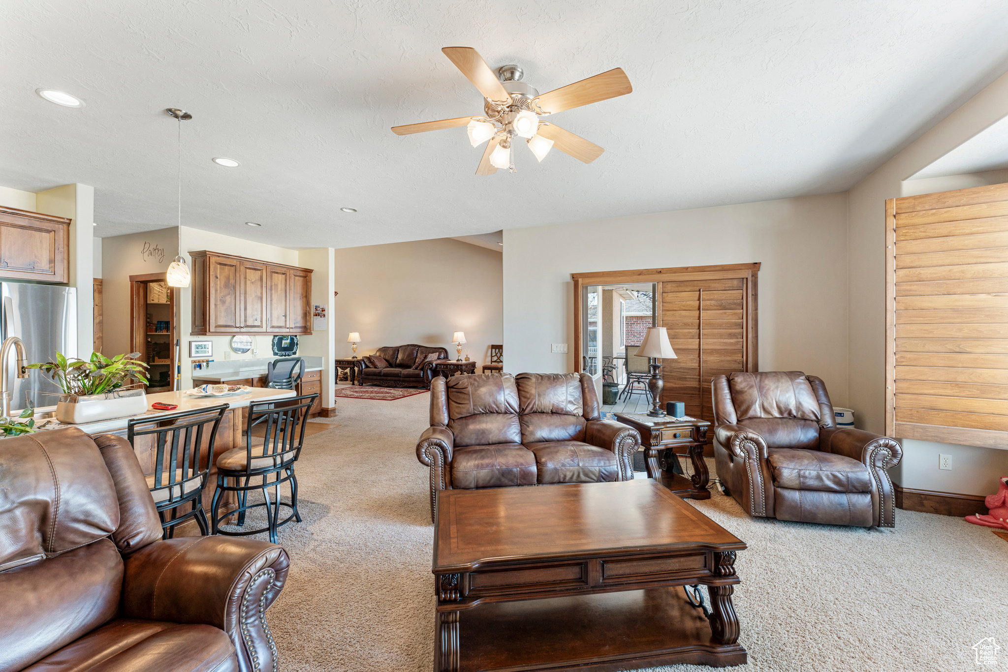 Living room featuring ceiling fan and light carpet