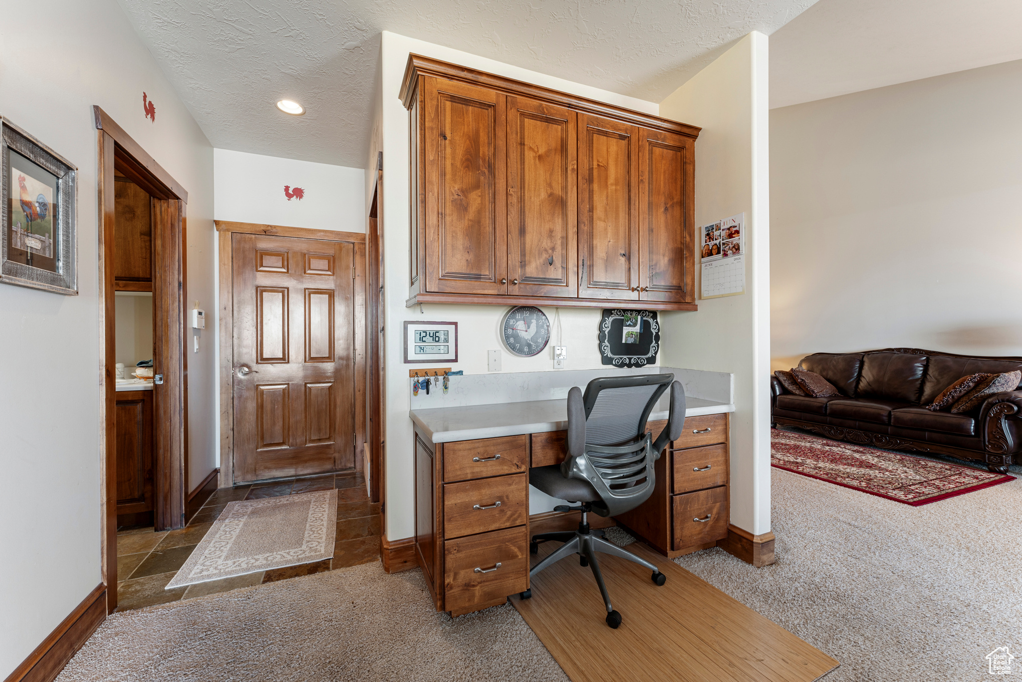 Carpeted office featuring a textured ceiling