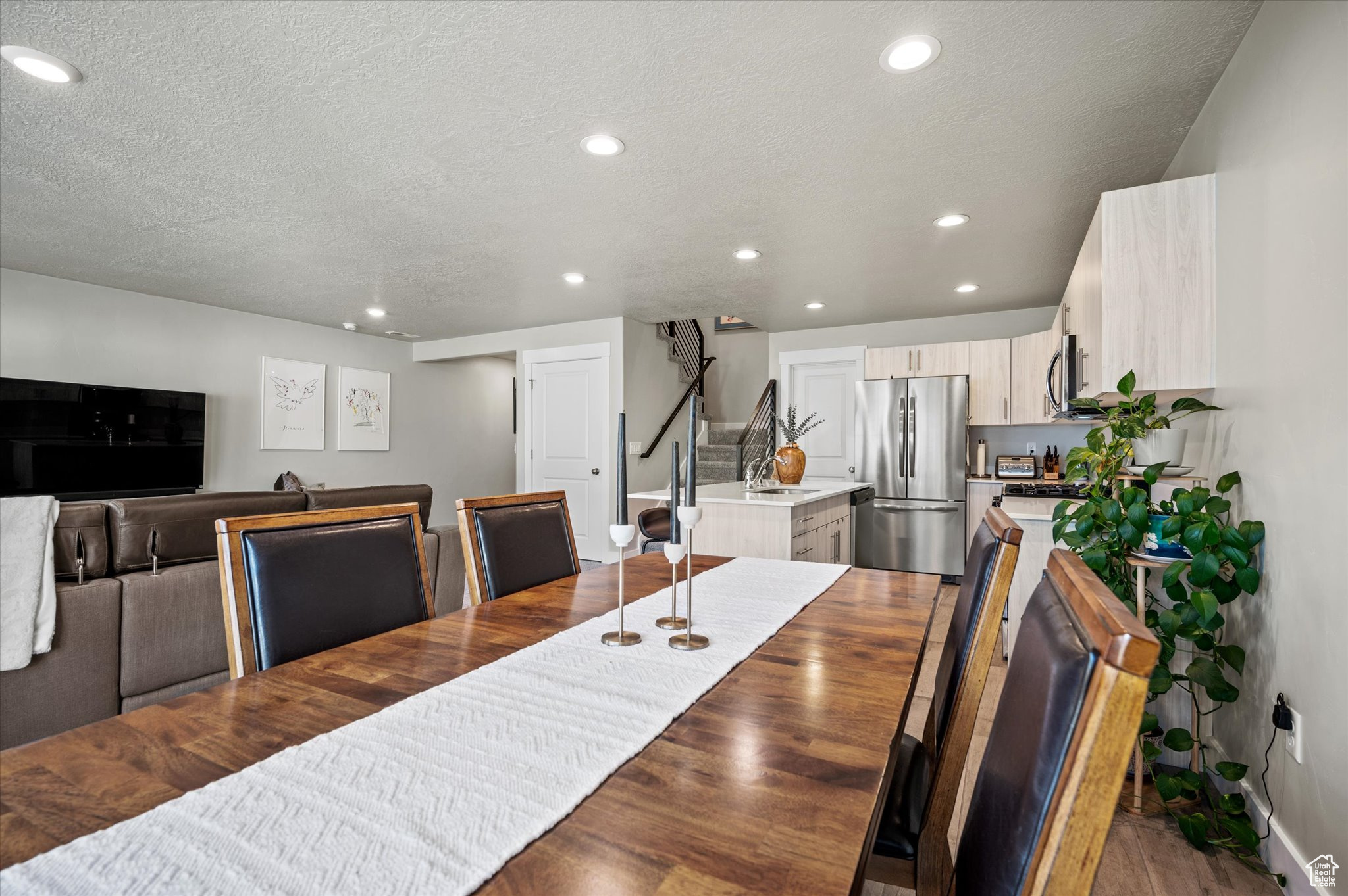 Dining space with sink, a textured ceiling, and light wood-type flooring