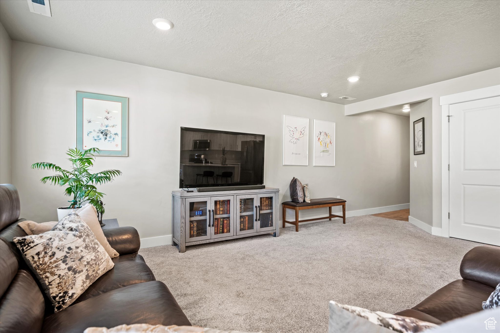 Living room featuring light colored carpet and a textured ceiling