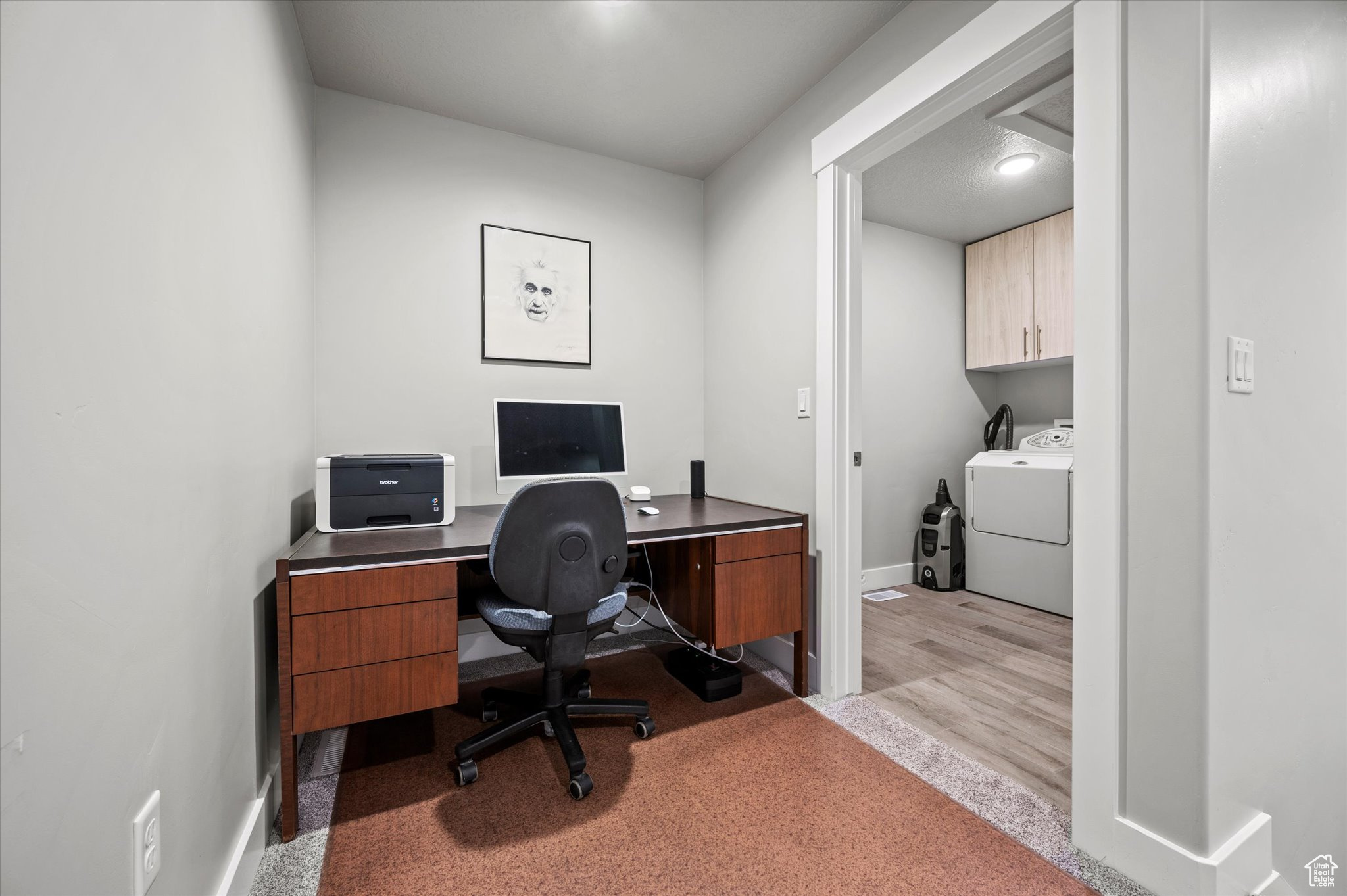 Home office with light carpet and washer and dryer