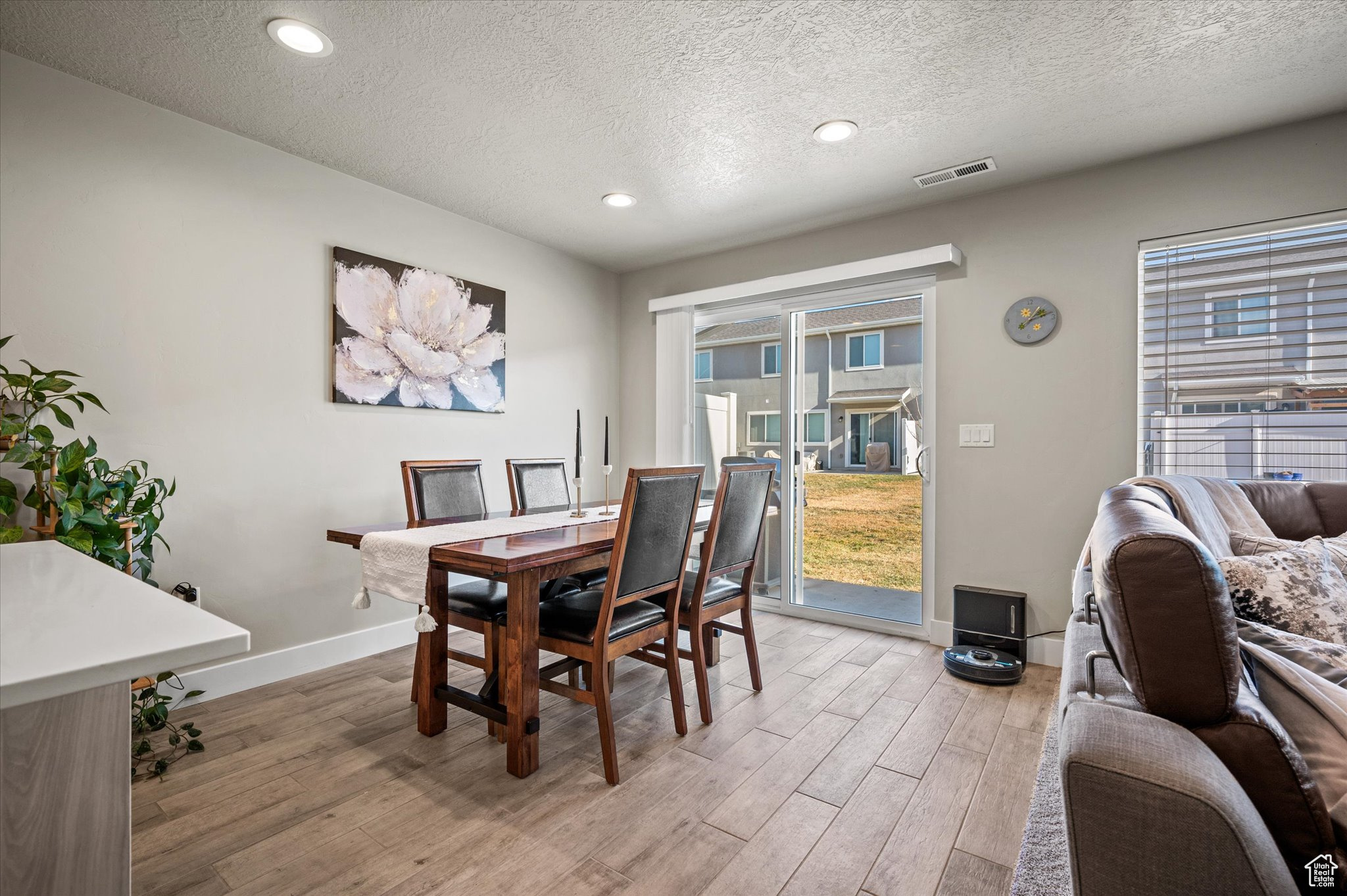 Dining space with a textured ceiling and light hardwood / wood-style flooring