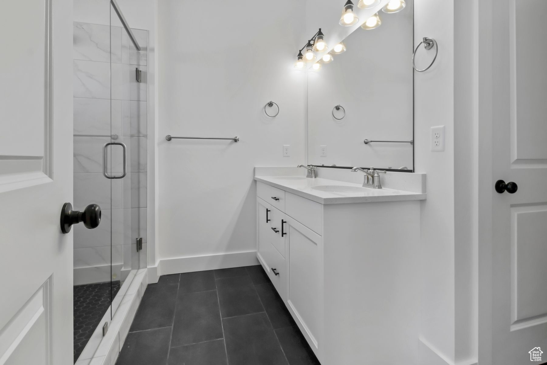 Bathroom featuring walk in shower, vanity, and tile patterned flooring