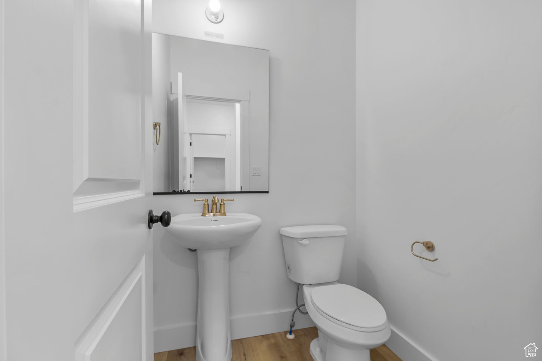 Bathroom featuring toilet, sink, and hardwood / wood-style floors