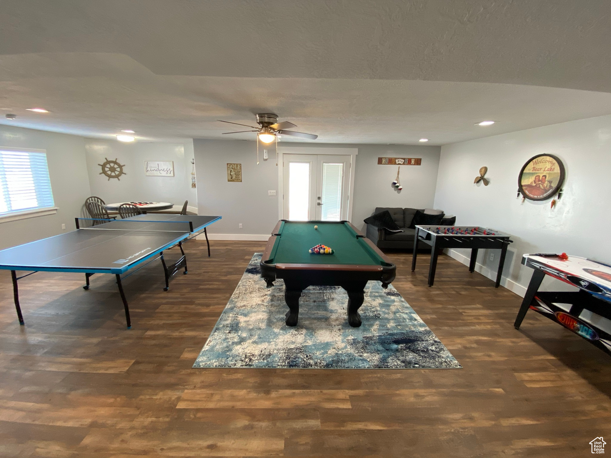 Game room with dark hardwood / wood-style floors, ceiling fan, french doors, and billiards