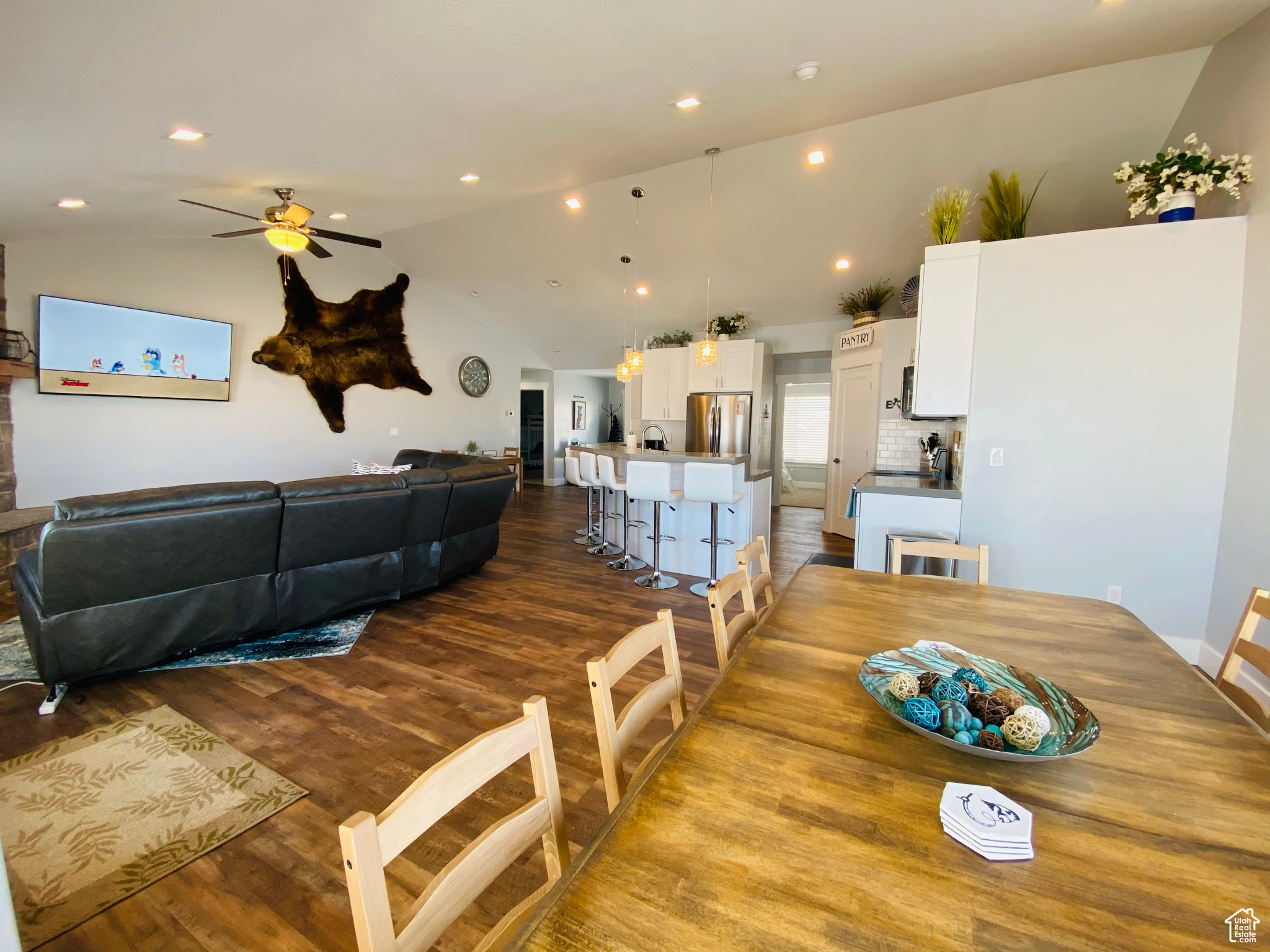 Dining room with ceiling fan, hardwood / wood-style flooring, and vaulted ceiling