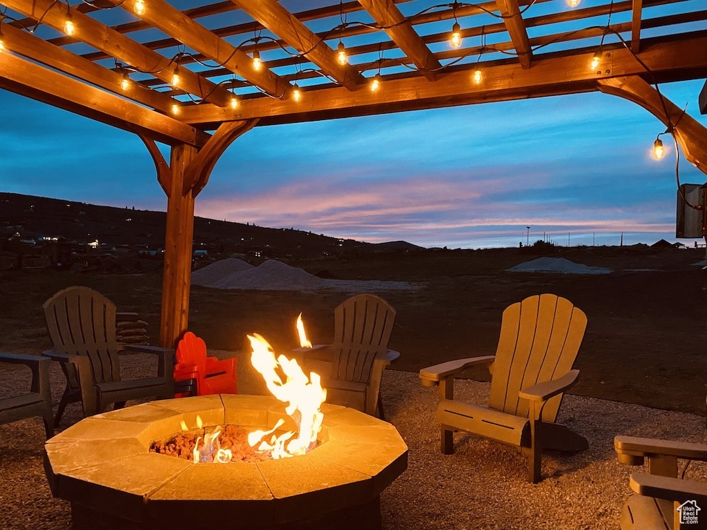 Patio terrace at dusk featuring an outdoor fire pit