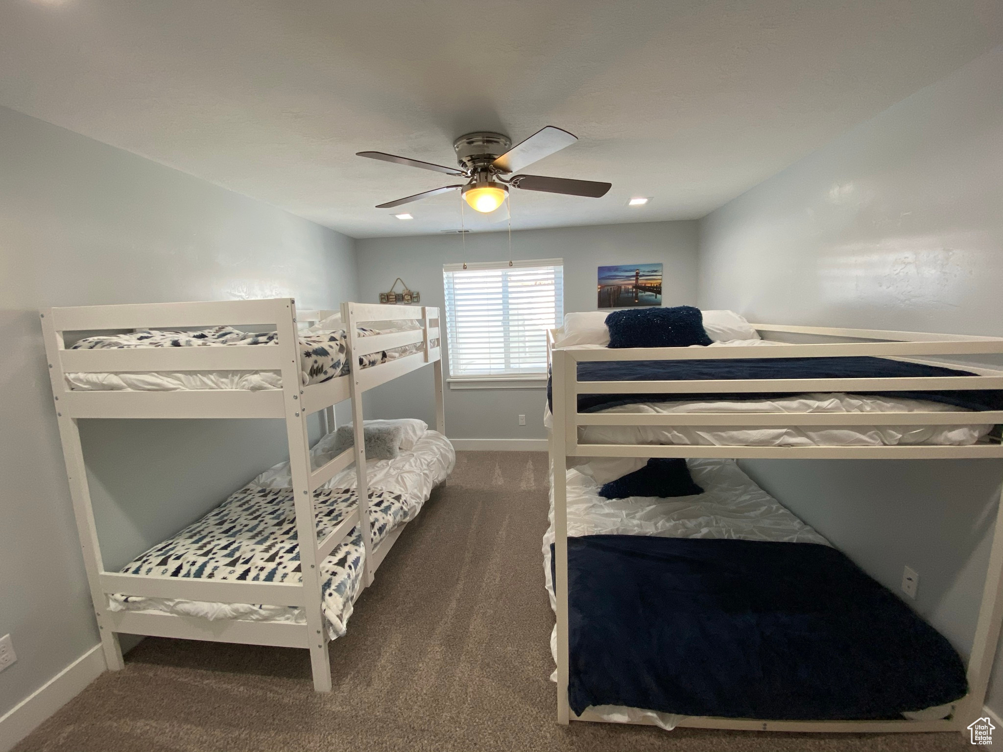 Bedroom featuring ceiling fan and dark carpet