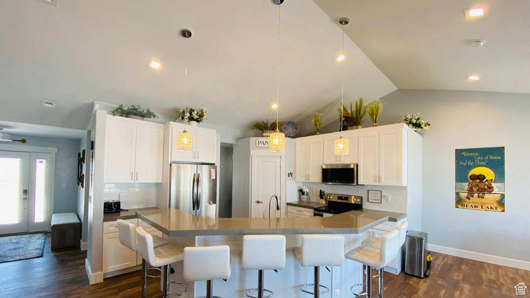 Kitchen with appliances with stainless steel finishes, decorative backsplash, and white cabinetry