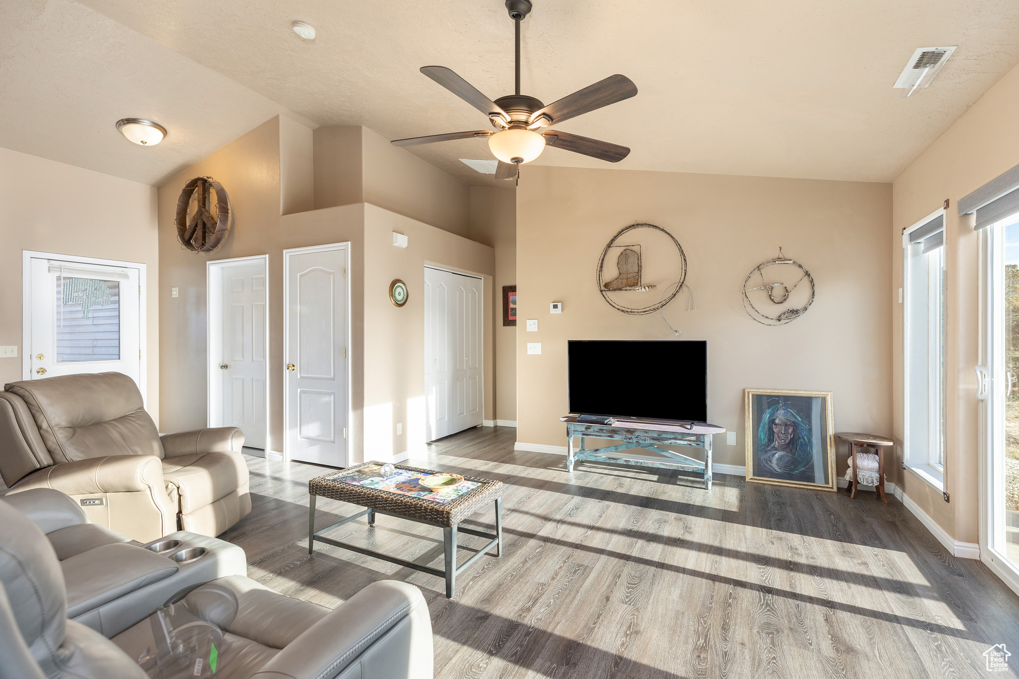 Living room with ceiling fan, lofted ceiling, and hardwood / wood-style flooring