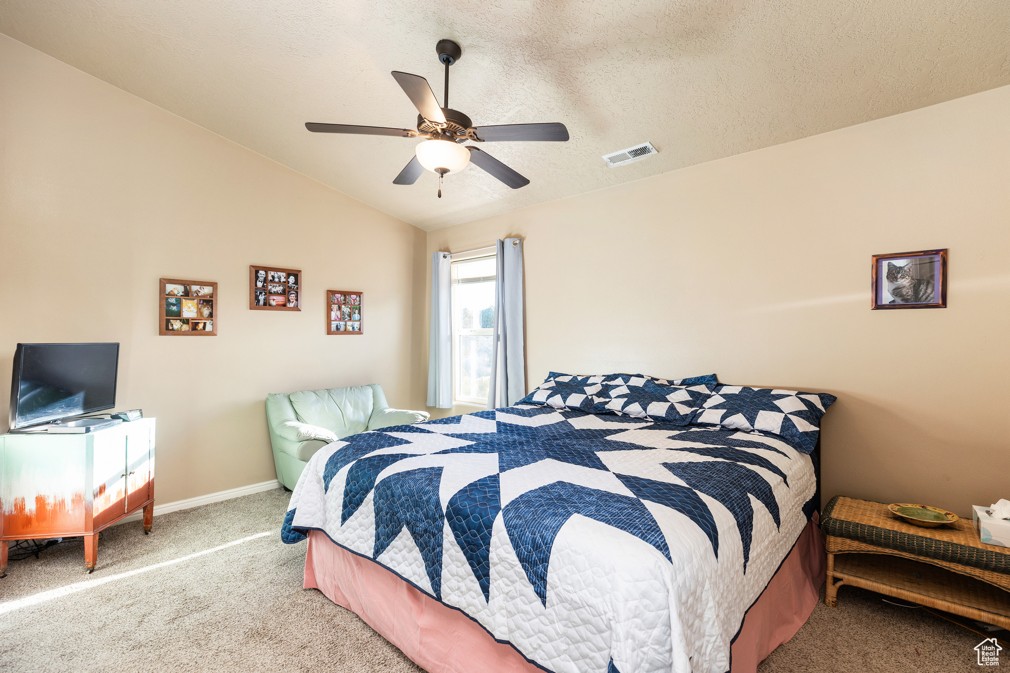 Carpeted bedroom featuring a textured ceiling, ceiling fan, and lofted ceiling