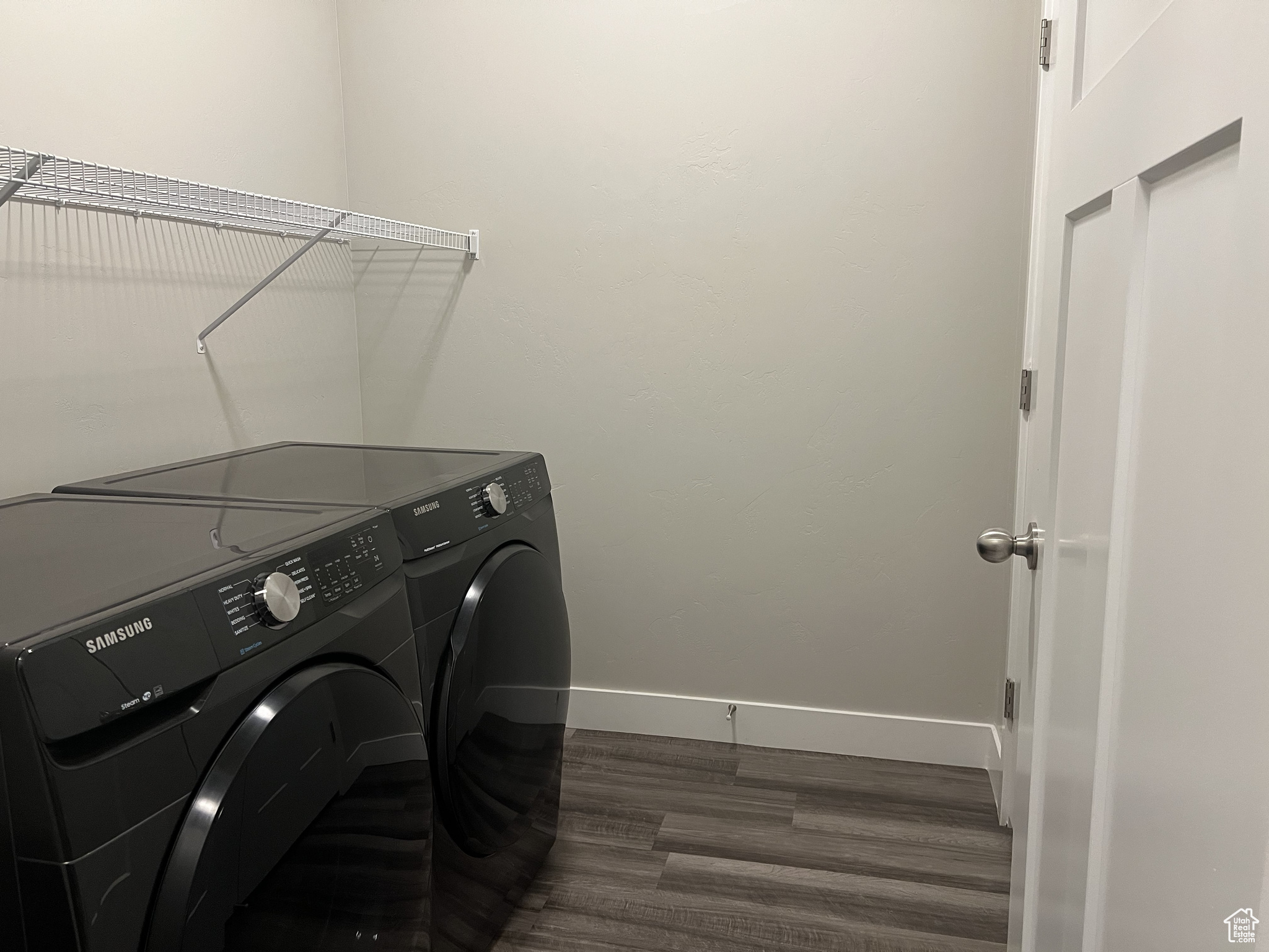 Washroom with washer and dryer and dark hardwood / wood-style flooring