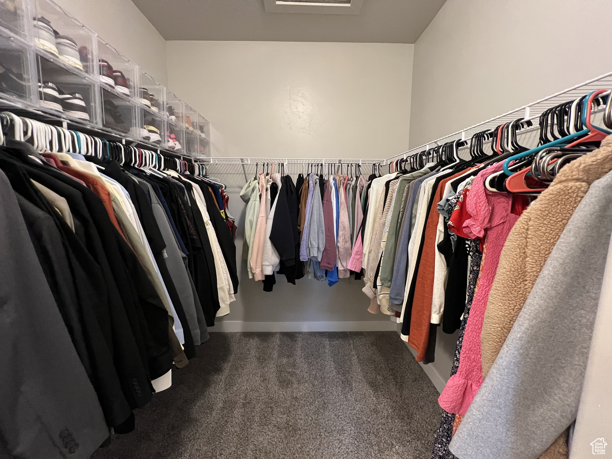 Walk in closet featuring dark colored carpet