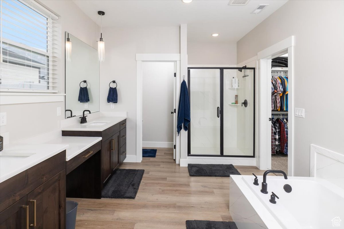 Bathroom featuring hardwood / wood-style flooring, vanity, and separate shower and tub