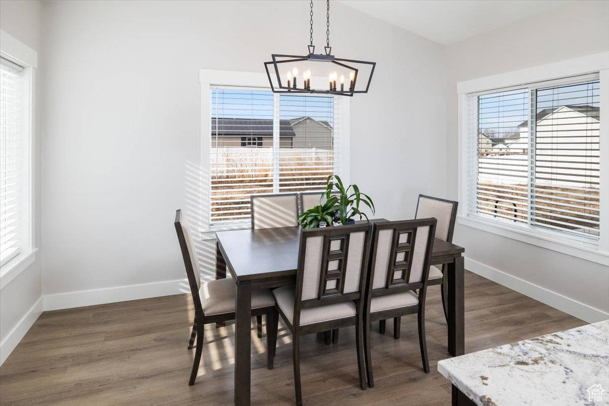 Dining room with a notable chandelier and dark hardwood / wood-style floors