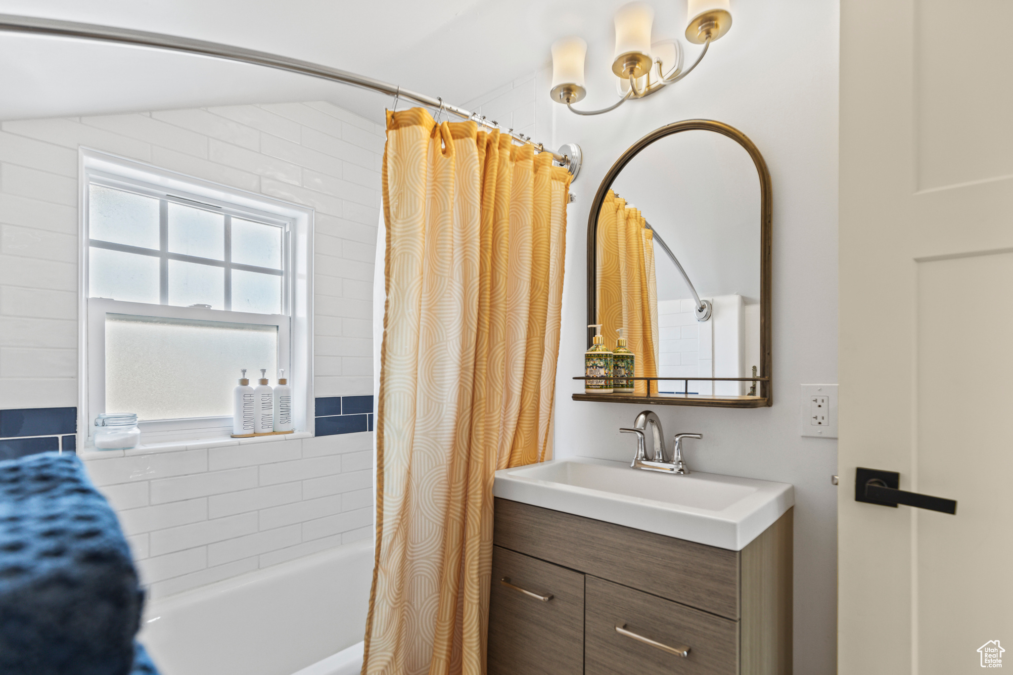 Bathroom with lofted ceiling, shower / bath combo, and vanity